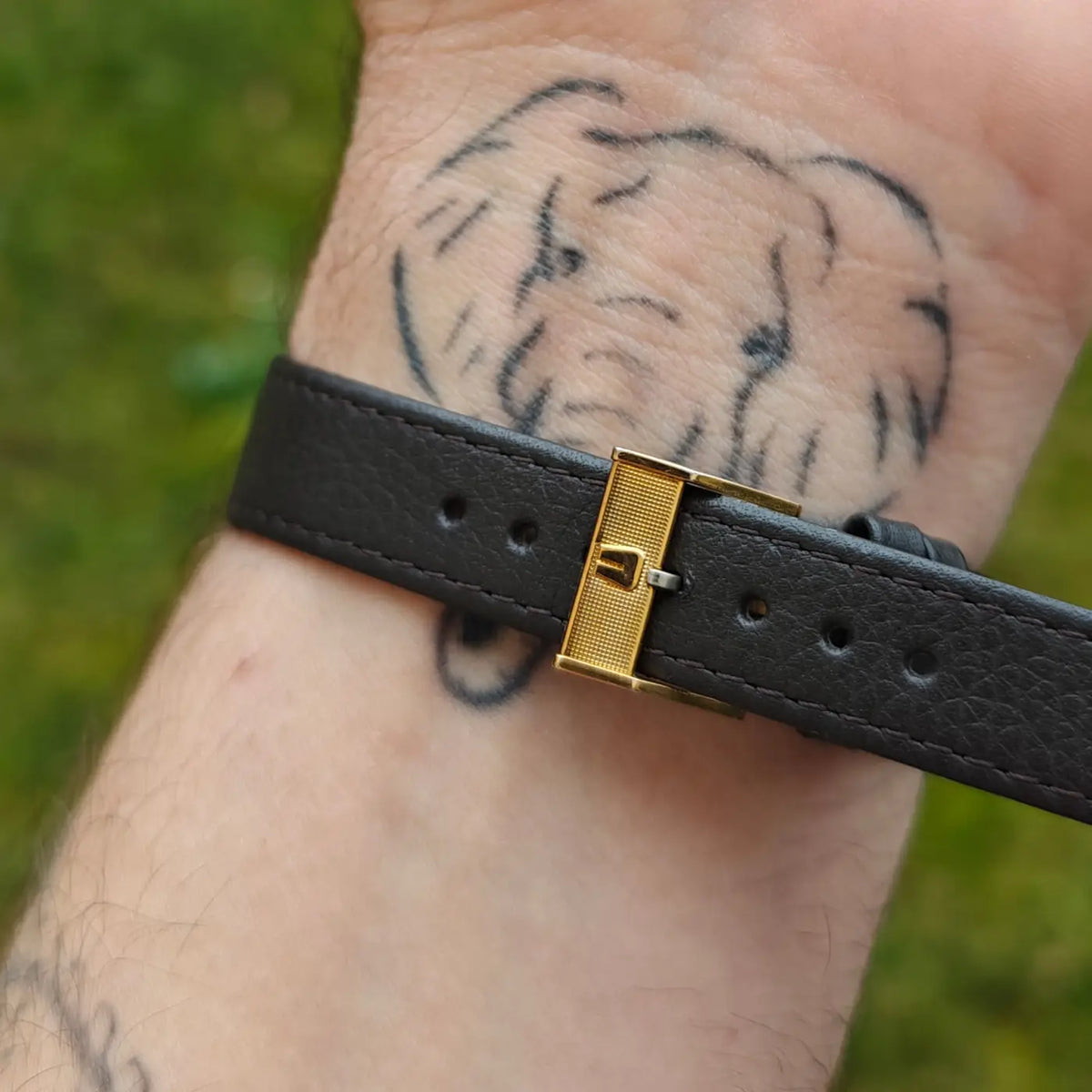 Detailaufnahme von schwarzem Lederband und goldfarbener Schließe einer Universal Genève mit Kaliber 42