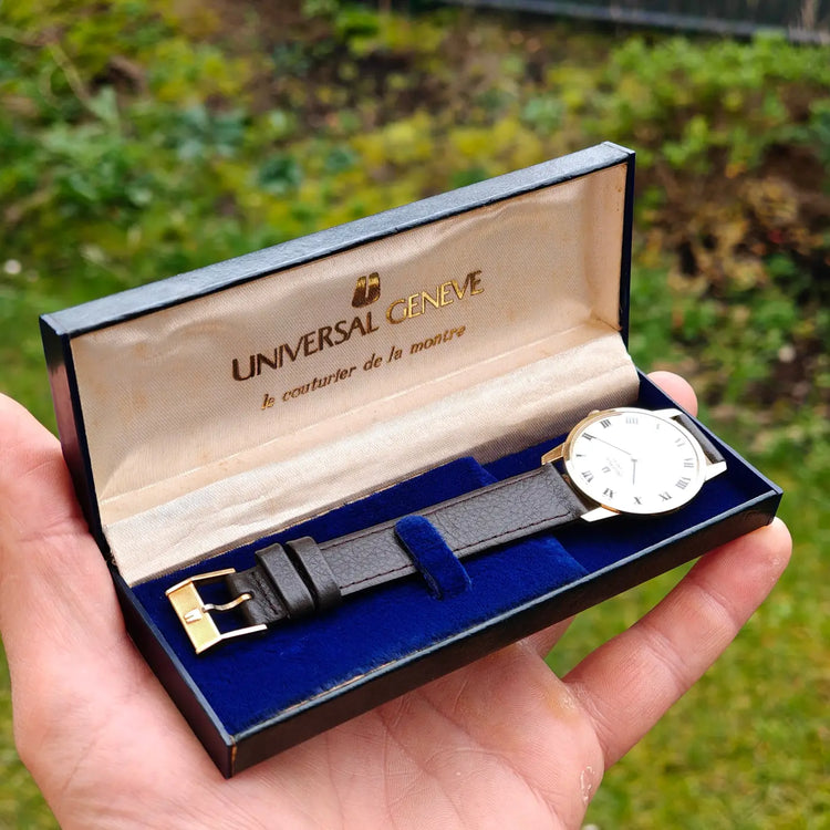 Universal Genève Vintage-Uhr mit weißem Zifferblatt, römischen Ziffern, goldfarbenem Gehäuse und schwarzem Lederband