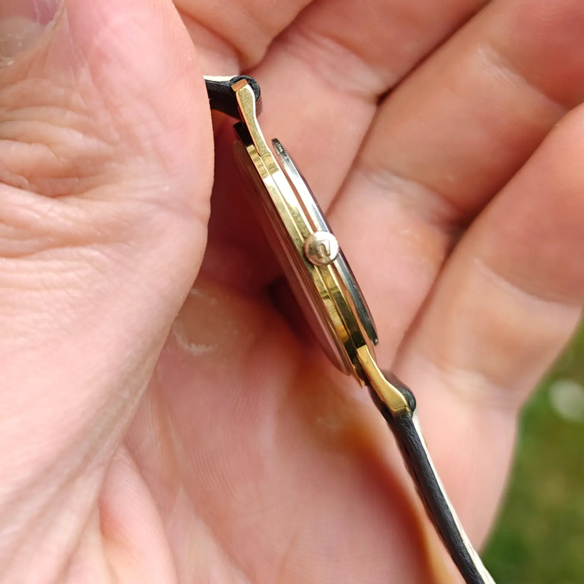 Universal Genève ultraflache Armbanduhr mit römischen Ziffern, poliertem Gehäuse und schwarzem Lederband